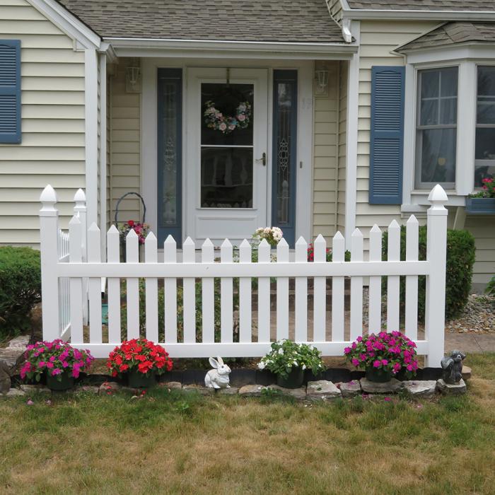 Richmond white picket fence in front of home with low flowers
