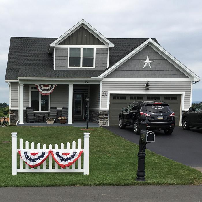 Ellington picket fence with american flag accent in front of house