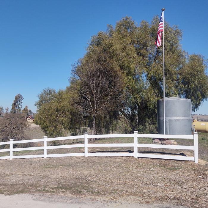 3-rail horse fencing in dry area with american flag