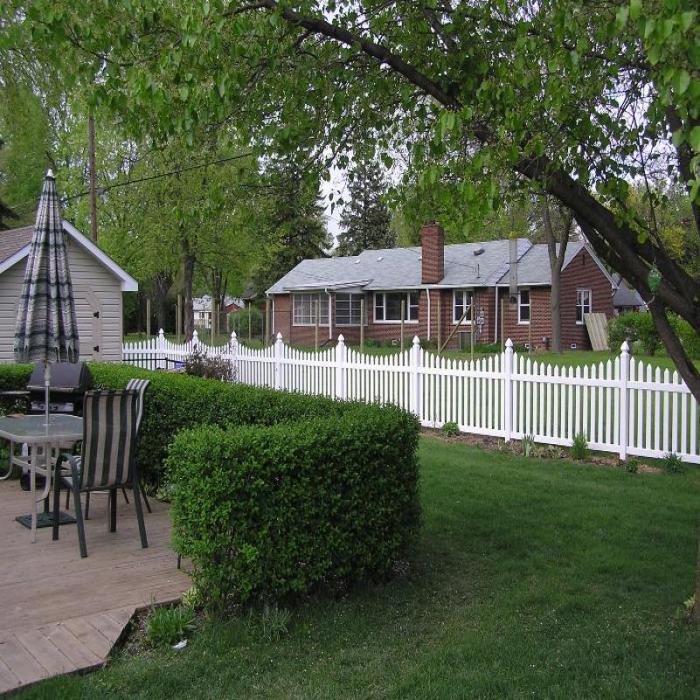 Ellington vinyl picket fence with scalloped pickets around patio and back yard